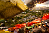 'The sun sets over a Ladakhi village outside of Leh, viewed through the flapping prayer flags; Ladakh, India '