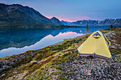 Scenic view of Lower Twin Lake with a backpacking tent in the foreground and sunset, Lake Clark National Park & Preserve, Southcentral Alaska