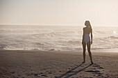 Rear view of a woman standing on the beach