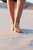 Low section view of woman walking on the beach