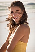 Happy young woman standing on the beach