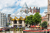 View over boats in the Oudehaven towards the yellow cube houses and the ''pencil'' high rise in the background, Rotterdam, Netherlands