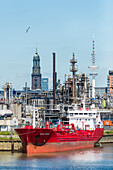 View at industrial plants in the Hamburg harbour with Michel and the television tower in the background, Hamburg, Germany