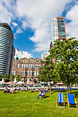Tourists and locals relaxing in front of the hotel New York, the former main building of the Holland America line, Rotterdam, Netherlands
