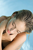 Frau entspannt im Pool mit geschlossenen Augen