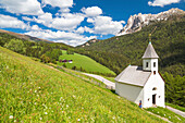 'Old woman outside the church; on the background Odle di Eores. Trentino Alto Adige, Italy.'