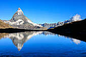 Hikers admire the Matterhorn reflected in Lake Stellisee Zermatt Canton of Valais Pennine Alps Switzerland Europe