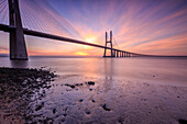 The colors of dawn on Vasco da Gama Bridge that spans the Tagus River in Parque das Na?º?Áes Lisbon Portugal Europe