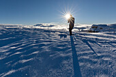 Europe, Italy, Belluno, Cortina d' Ampezzo, Dolomites. Landscape photographer in silhouette towerds the sun light.