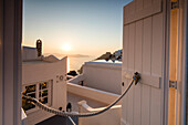 Sunset on Aegean Sea seen from a typical Greek house in the old village of Firostefani Santorini Cyclades Greece Europe