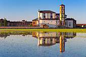 Abbey of Lucedio reflecting on rice fields at sunset, Trino Vercellese, Piedmont, Italy.