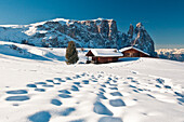 Traditional huts of the Dolomites after a winter snowfall overlook the scenery of the Group Sciliar. Siusi. Western Dolomites. Trentino Alto Adige. Italy. Europe