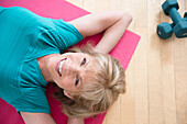 Older Caucasian woman relaxing on exercise mat