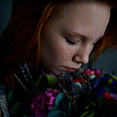 Caucasian teenage girl smelling flowers