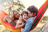 Family relaxing together on hammock, portrait