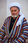 Uzbekistan, Bukhara, Unesco world heritage, Uzbek men playing chess in traditional clothes chapan.