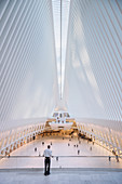 ein Wachmann blickt in the Oculus auf Passanten, futuristischer Bahnhof des Star Architekten Santiago Calatrava bei der World Trade Center Gedenkstätte, Manhattan, New York, USA, Vereinigte Staaten von Amerika