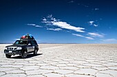 Jeep carrying tourists through the Uyuni Salt Flats, Bolivia