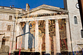 Italy, Umbria, Assisi, Piazza del Comune, Temple of Minerva reflection on a souvenir shop's window