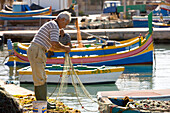 Malta, South Coast, Marsaxlokk, fishermen checking his nets