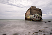 Ein Betonteil einer alte Bunkeranlage der DDR liegt in der Ostsee am Hohen Ufer auf dem Darß. Hohes Ufer, Ahrenshoop, Darß, Mecklenburg-Vorpommern, Deutschland