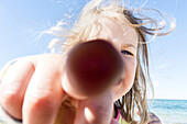 Little girl in backlight pointing his finger at the camera. Dierhagen, Darß, Mecklenburg-Vorpommern, Germany