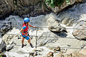 Frau begeht über Seilbrücke Obergurgler Klettersteig, Bergbach im Hintergrund, Obergurgler Klettersteig, Obergurgl, Ötztaler Alpen, Tirol, Österreich