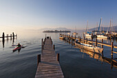 Landing stages at the harbour, view over Chiemsee to Fraueninsel, near Gstadt, Bavaria, Germany