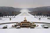 France, Yvelines, snow covered park of the Chateau de Versailles, listed as World Heritage by UNESCO, the Latona Basin and gardens perspective and the Axe du Soleil (the Sun Axis) to the frozen Grand Canal