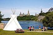 Canada, Ontario Province, Ottawa, Victoria Island, Aboriginal Experiences, teepee and the Parliament of Canada in the background