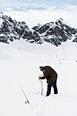 fisherman and snowy winter landscape, Melchsee-Frutt, Canton of Obwalden, Switzerland