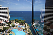 Blick auf Schwimmbad von Hotel Sol Calas de Mallorca Resort mit Spiegelung im Fenster, Calas de Mallorca, Mallorca, Balearen, Spanien