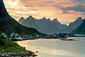 Sunset on the fishing village surrounded by rocky peaks and sea, Reine, Nordland county, Lofoten Islands, Arctic, Northern Norway, Scandinavia, Europe