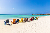 A row of colourful wooden deckchairs on Palm Beach, Aruba, Netherlands Antilles, Caribbean, Central America