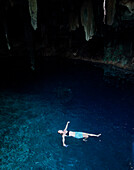A woman floating in the Merida cenotes.