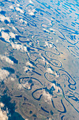 Aerial view of Oxbow rivers and streams and clouds stretch through the tundra landscape, North Slope, Alaska, United States of America