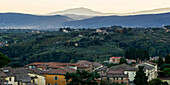 Silhouetted mountains in the distance at dusk and houses in the foreground, Siena, Italy