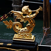 A gold sculpture of a mermaid blowing a horn, Venice, Italy