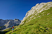 Woman hiking towards Ehrwalder Sonnenspitze, Ehrwalder Sonnenspitze, Mieming range, Tyrol, Austria