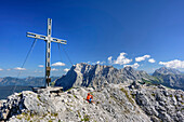 Woman sitting at summit of Ehrwalder Sonnenspitze, Wetterstein range with Zugspitze in background, Ehrwalder Sonnenspitze, Mieming range, Tyrol, Austria