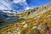 Woman hiking descending from hut Richterhuette, Reichenspitz-Group in background, hut Richterhuette, Natural Park Zillertal Alps, Dreilaendertour, Zillertal Alps, Salzburg, Austria