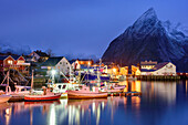 Bay with illuminated boats and houses of Hamnoy, Hamnoy, Lofoten, Norland, Norway