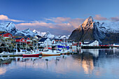 Meeresbucht mit Booten und Häusern von Hamnoy, verschneite Berge im Hintergrund, Hamnoy, Lofoten, Norland, Norwegen