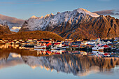 Meeresbucht mit Häusern von Reine und verschneiten Bergen im Hintergrund, Reine, Lofoten, Norland, Norwegen