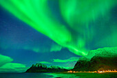 Aurora borealis, Polarlicht über Strand und verschneiten Bergen, Lofoten, Norland, Norwegen