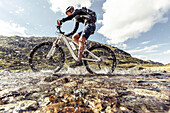 Mountainbikerin spritzt durch Gebirgsbach am Giglachsee, Niedere Tauern, Steiermark, Österreich