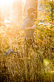 Young man running through a colorful autumn forest, Allgaeu, Bavaria, Germany