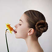 Caucasian girl licking yellow flower