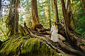 Caucasian woman standing on root in forest