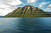 Wunderschöner grün bewachsener Berg am Meer, Färöer Inseln